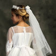 Girls in a white flower girl dress wearing a Rhinestone Crown with Veil