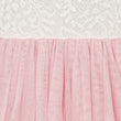 Close-up of pink tulle fabric with white lace in the background