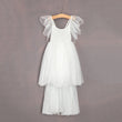 White tulle dress on a wooden hanger against a gray background