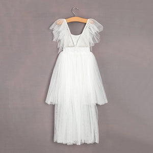 White dress with ruffled straps on a wooden hanger against a gray background
