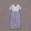 Lace top and floral skirt dress on a hanger against a gray background