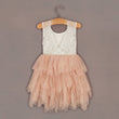Lace top and layered tulle skirt dress on a hanger against a plain background