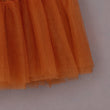 Close-up of an orange tulle skirt on a neutral background