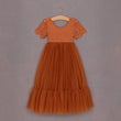 Orange lace dress on a hanger against a gray background