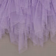 Close-up of a purple tulle skirt on a plain background