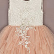 White lace top and peach tulle skirt dress with floral embroidery on a plain background
