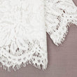 Close-up of white lace fabric on a brown background