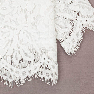 Close-up of white lace fabric on a brown background