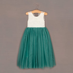 Teal dress with white lace top on a hanger against a brown background