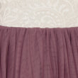 Close-up of a dress with a white lace top and purple skirt.