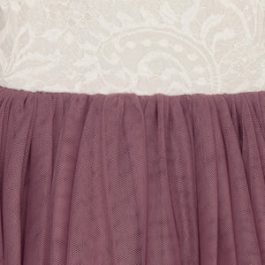 Close-up of a dress with a white lace top and purple skirt.