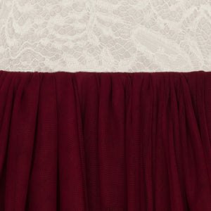 Close-up of burgundy fabric with a textured white lace background
