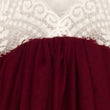Close-up of a burgundy fabric with lace trim in the background