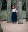 young girl holding to trees
