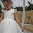 close up of girl in a white tulle and appliqué dress