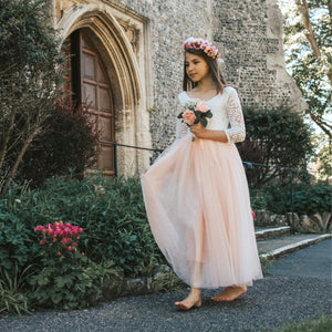 Young girl in a floral dress standing in front of a church entrance.