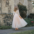 girl in a white dress standing in front of an old stone building