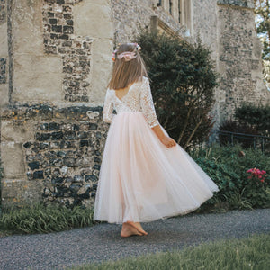 girl in a white dress standing in front of an old stone building