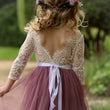 Girl wearing a lace top and pink dress with a blurred green background