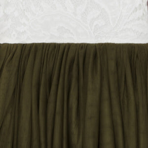 Close-up of olive green fabric against a textured white background