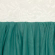 Close-up of teal fabric with a textured white background
