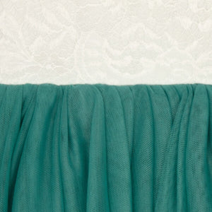 Close-up of teal fabric with a textured white background