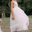 girl wearing a white dress with a lace top in an outdoor setting