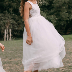 girl wearing a white dress with a lace top in an outdoor setting