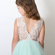 Girl wearing a lace top and mint green skirt against a white background
