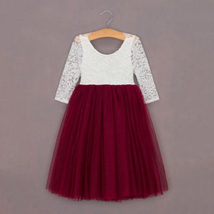White lace top and red tulle skirt dress on a hanger against a gray background