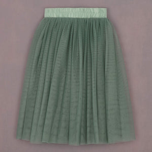 Green pleated skirt on a pink background