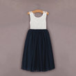 White lace top and navy blue skirt dress on a hanger against a brown background