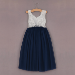 Navy blue dress with white lace top on a hanger against a gray background