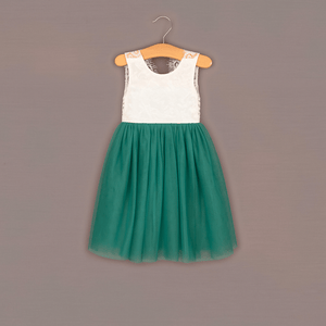 Green dress with white top on a hanger against a gray background