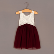 White lace top and burgundy skirt dress on a hanger against a gray background