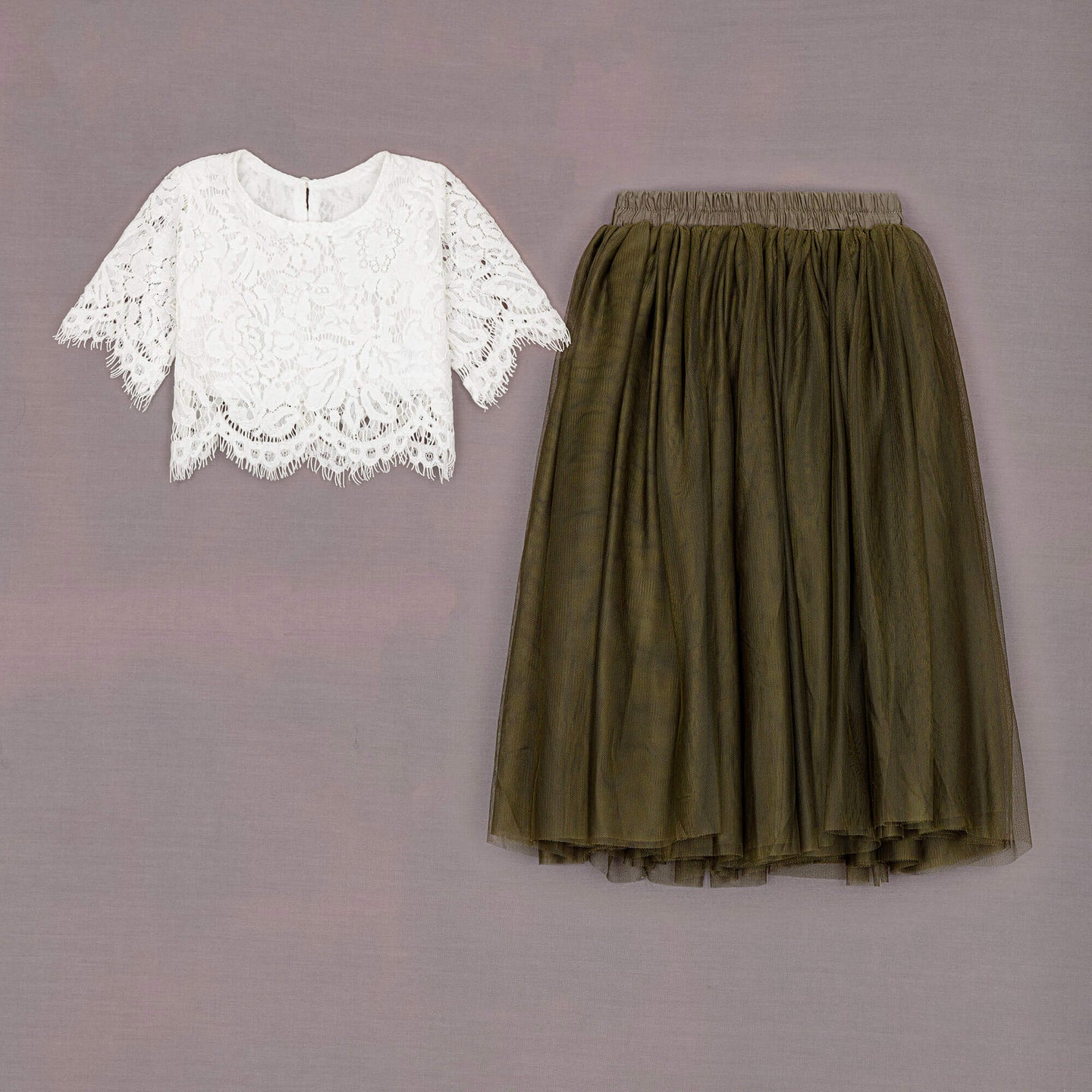 White lace top and green skirt on a gray background