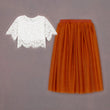 White lace top and orange tulle skirt on a grey background