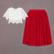 White lace top and red skirt on a gray background