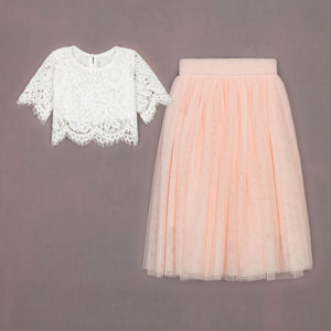 White lace top and pink tulle skirt on a gray background