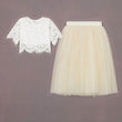 White lace top and cream tulle skirt on a brown background