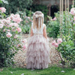 Young girl in wedding gardens wearing flower girl dress