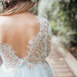 Lace-trimmed dress with floral details in a natural setting