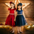 two girls in red and blue satin party dresses