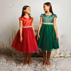 Two girls smiling holding dresses