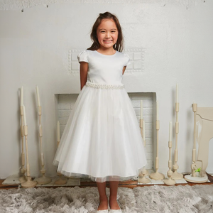 Smiling girl wearing a White party dress from uk flower girl boutique