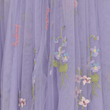 Embroidered floral design on a purple fabric