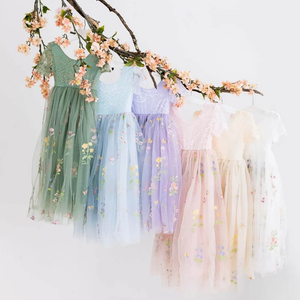 Enchanted Willow Dresses in various colours hanging from a branch