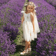 Young girl in a white dress standing in a field of lavender