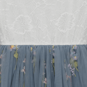 Blue embroidered skirt with floral patterns on a textured white background