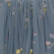Blue tulle fabric with floral embroidery on a dark background